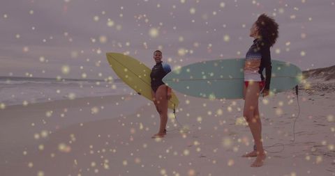 Joyful surfers with boards on beach during cloudy sunset