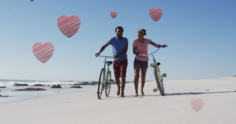 Romantic couple with bikes on beach surrounded by hearts