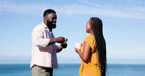 Couple relaxing on balcony with ocean view