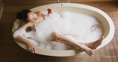 Tranquil Woman Relaxing in Bubble Bath with Wine Glass