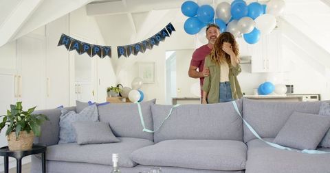 Couple Celebrating Birthday with Balloons in Cozy Living Room