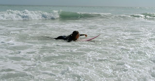 Young biracial woman catches waves at the beach, with copy space - Download Free Stock Photos Pikwizard.com