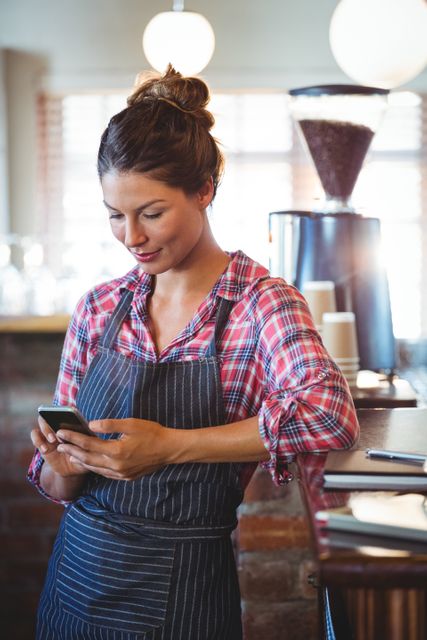 Waitress using a smartphone in a cafe