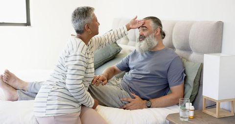 Senior Couple Sharing Intimate Moment in Cozy Bedroom Setting