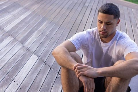 Man Relaxing on Wooden Deck in Sportswear Outdoors