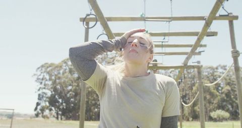 Exhausted female soldier on army obstacle course