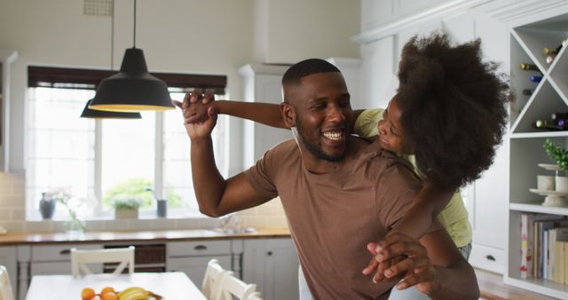 Happy African American Father Piggybacking Daughter in Modern Kitchen - Download Free Stock Images Pikwizard.com