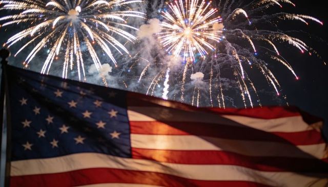 Waving american flag under sparkling fireworks display: patriotic fourth of july night