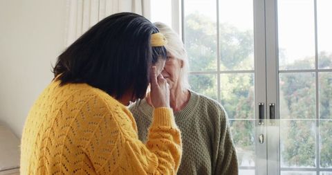 Senior Friends Offering Support at Home Near Window