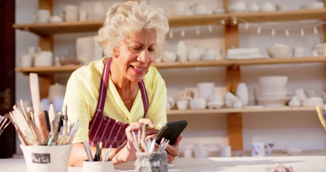 Senior Woman Using Smartphone in Pottery Studio - Download Free Stock Images Pikwizard.com