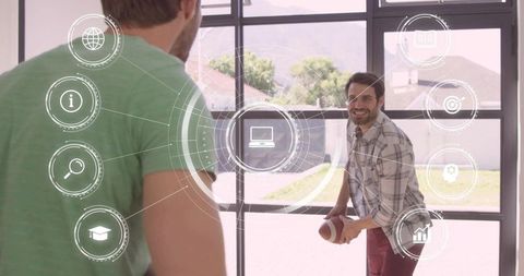 Smiling man tossing football indoors by grid glass door with floating digital icons