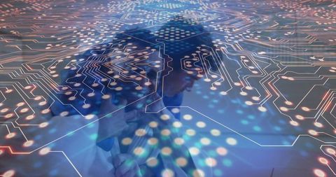 Professionals collaborating over digital circuit blueprint with futuristic data overlay