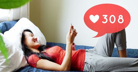 Woman Engaging with Social Media on Smartphone in Cozy Bedroom