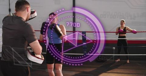 Female boxer training with coach punching focus mitts in ring with hud fitness overlay