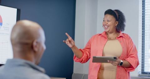 African American Businesswoman Presenting with Tablet to Team in Modern Office Meeting
