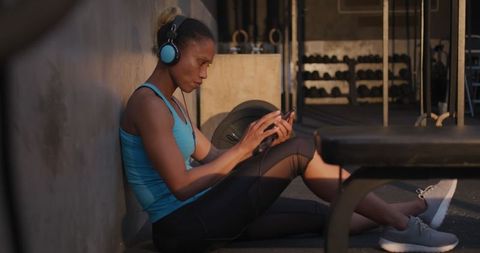 Athletic Woman Relaxing with Music in Casual Gym Environment - Download Free Stock Images Pikwizard.com