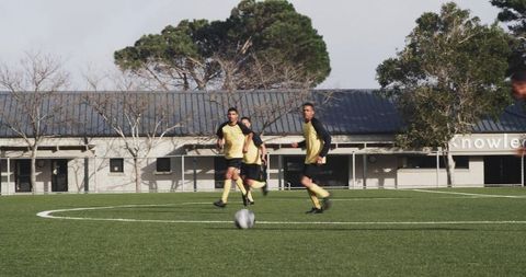 Soccer Players Strategizing on Field During Intense Match