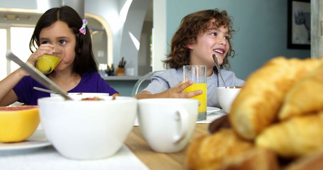 Smiling Children Eating Breakfast Together with Fresh Juice - Download Free Stock Images Pikwizard.com