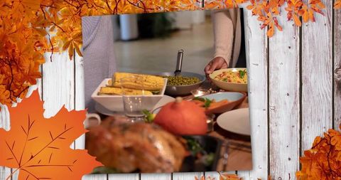 Autumn family gathering serving salad and roasted turkey at rustic cozy dining table