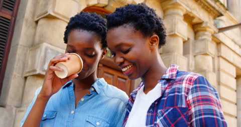 African American Twins Smiling and Enjoying Coffee Together