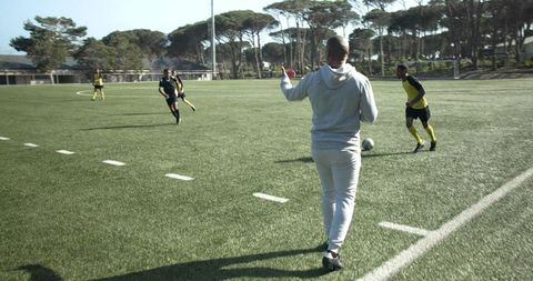 Coach guiding soccer team strategy during practice match