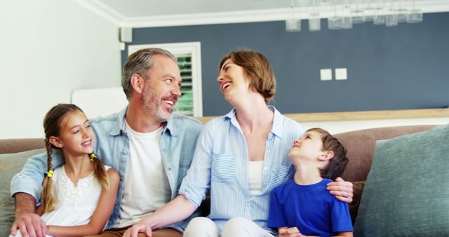 Smiling Family of Four Enjoying Quality Time on Sofa - Download Free Stock Images Pikwizard.com