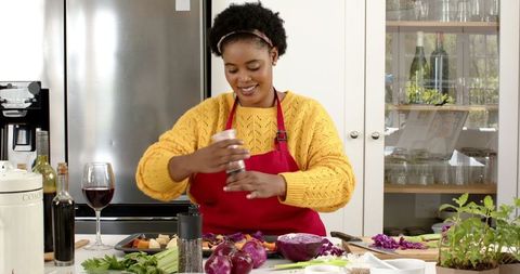 Woman Enjoying Cooking in Modern Sunlit Kitchen