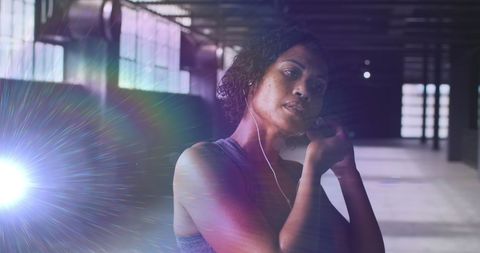 Woman preparing for workout with earphones in modern gym