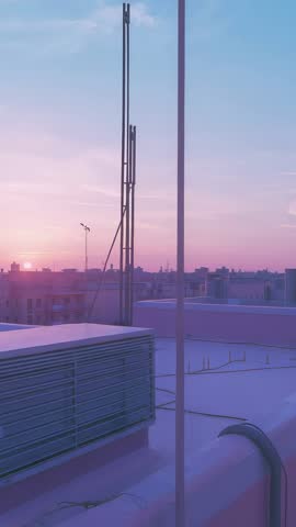 Panning rooftop AC unit at pastel twilight revealing metal poles, coiled hoses, distant skyline