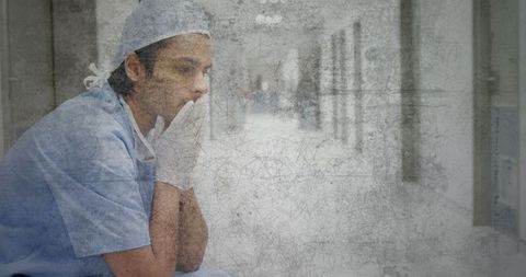 Stressed Medical Professional Sitting in Hospital Corridor
