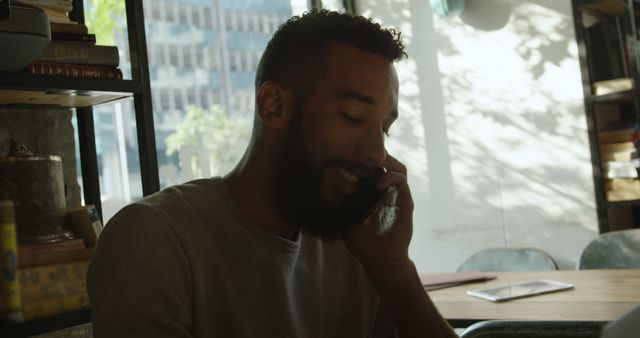 Smiling Man Having Phone Conversation in Office - Download Free Stock Images Pikwizard.com