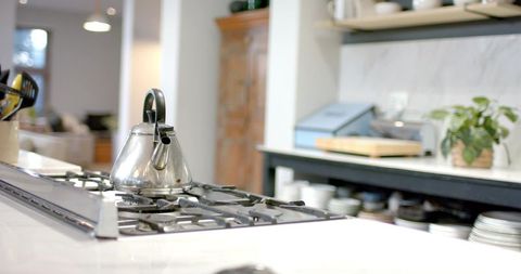 Modern kitchen interior with steel kettle on gas cooktop