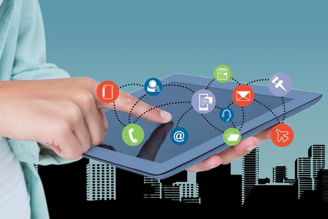 This image showcases a hand interacting with a digital tablet displaying various colorful social media and communication icons with a cityscape background. Use this for themes related to technology, online communication, social media, internet networking, and modern business. Ideal for blogs, websites, or marketing materials about digital tools, online interaction, or urban connectivity.