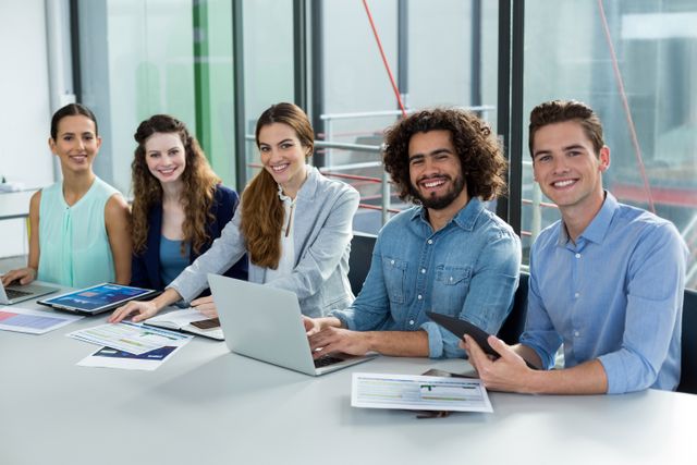 Group of young professionals collaborating in a modern office environment. Ideal for illustrating teamwork, corporate culture, and modern business practices. Suitable for business presentations, corporate websites, and marketing materials.