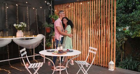Couple Embracing on Elegant Patio for Romantic Dinner