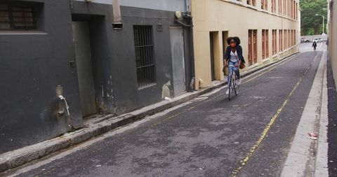 Woman Riding Bicycle Down Urban Street Wearing Mask - Download Free Stock Images Pikwizard.com