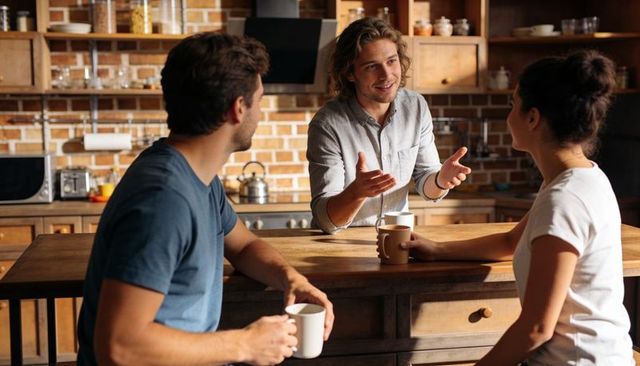 Friends chatting over coffee at rustic kitchen island cozy casual morning conversation