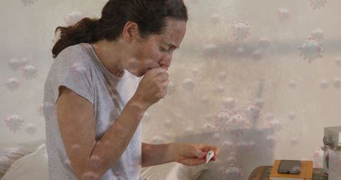Sick woman coughing while taking temperature amid covid-19