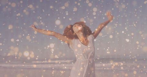 Joyful Woman Embracing Freedom at Sunny Beach with Golden Lights