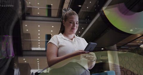 Businesswoman Using Smartphone in Modern Office Atrium