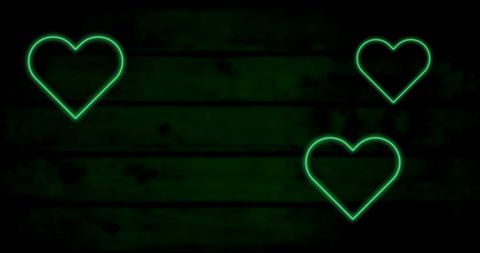 Green neon heart shapes on dark wooden background
