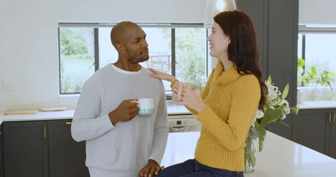 Diverse Couple Chatting Over Coffee in Modern Kitchen