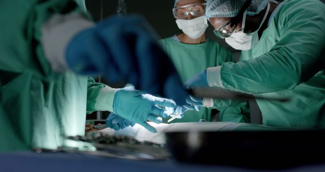 Diverse surgeons with face masks during surgery in operating room in slow motion. Medicine, health and care.