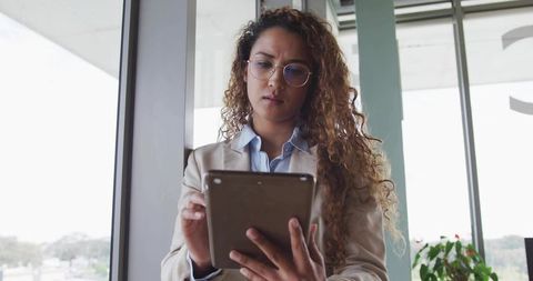 Businesswoman Analyzing Data on Tablet in Urban Office