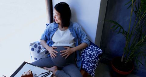 Expectant Mother Reflecting on Motherhood in Relaxed Setting