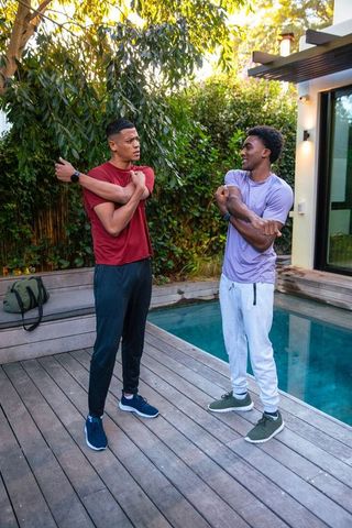 Healthy Active Lifestyle: Friends Stretching by Pool in Vibrant Backyard