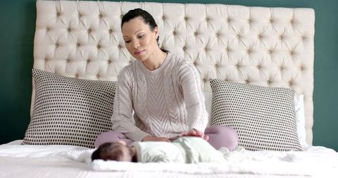 Mother Bonding with Infant on Cozy Bed in Modern Bedroom