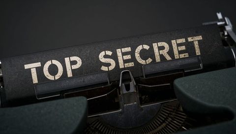 Vintage typewriter displaying top secret on aged platen close-up moody macro detail