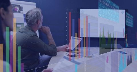 Mature professional analyzing complex data visualizations during conference room briefing