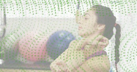 Young woman stretching in gym with floating binary code overlay, fitness meets technology